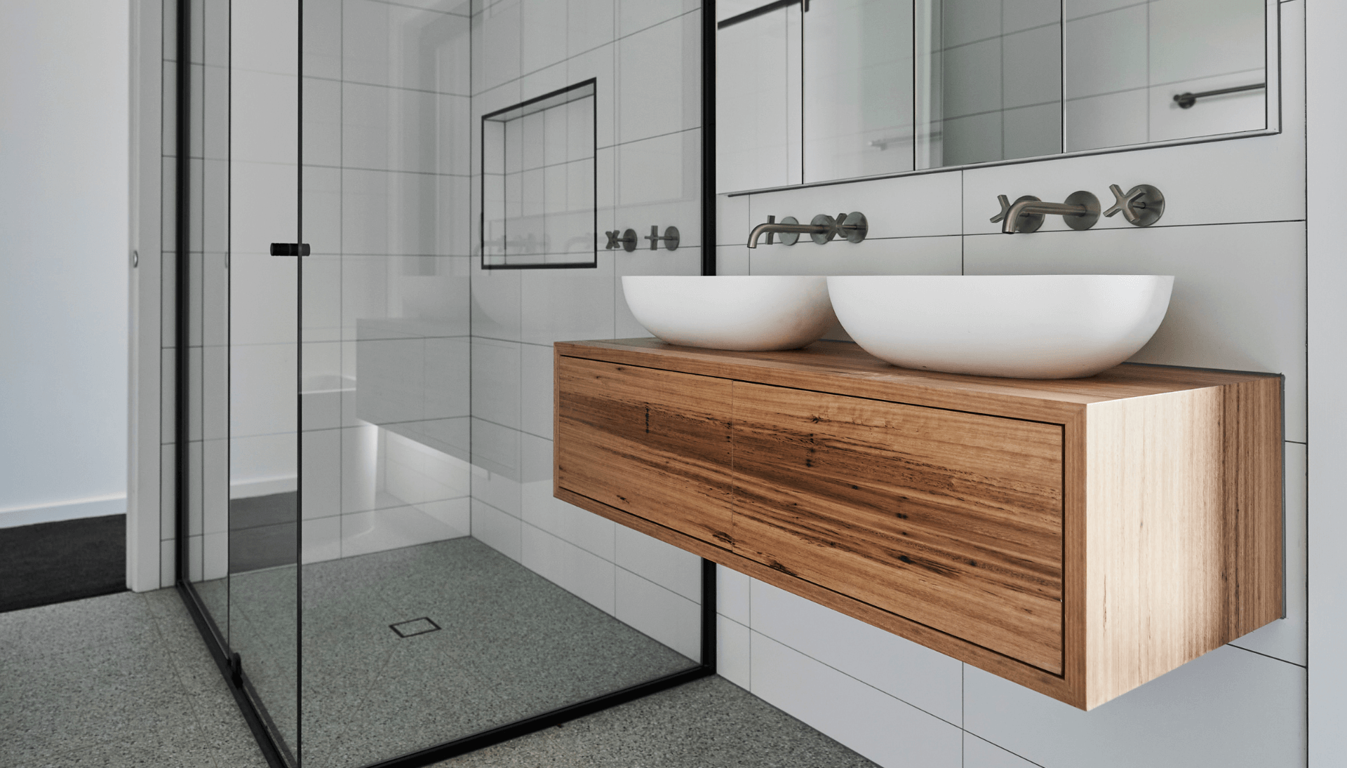 Bathroom with white wall tiles, double vanity basins and wall-mounted taps